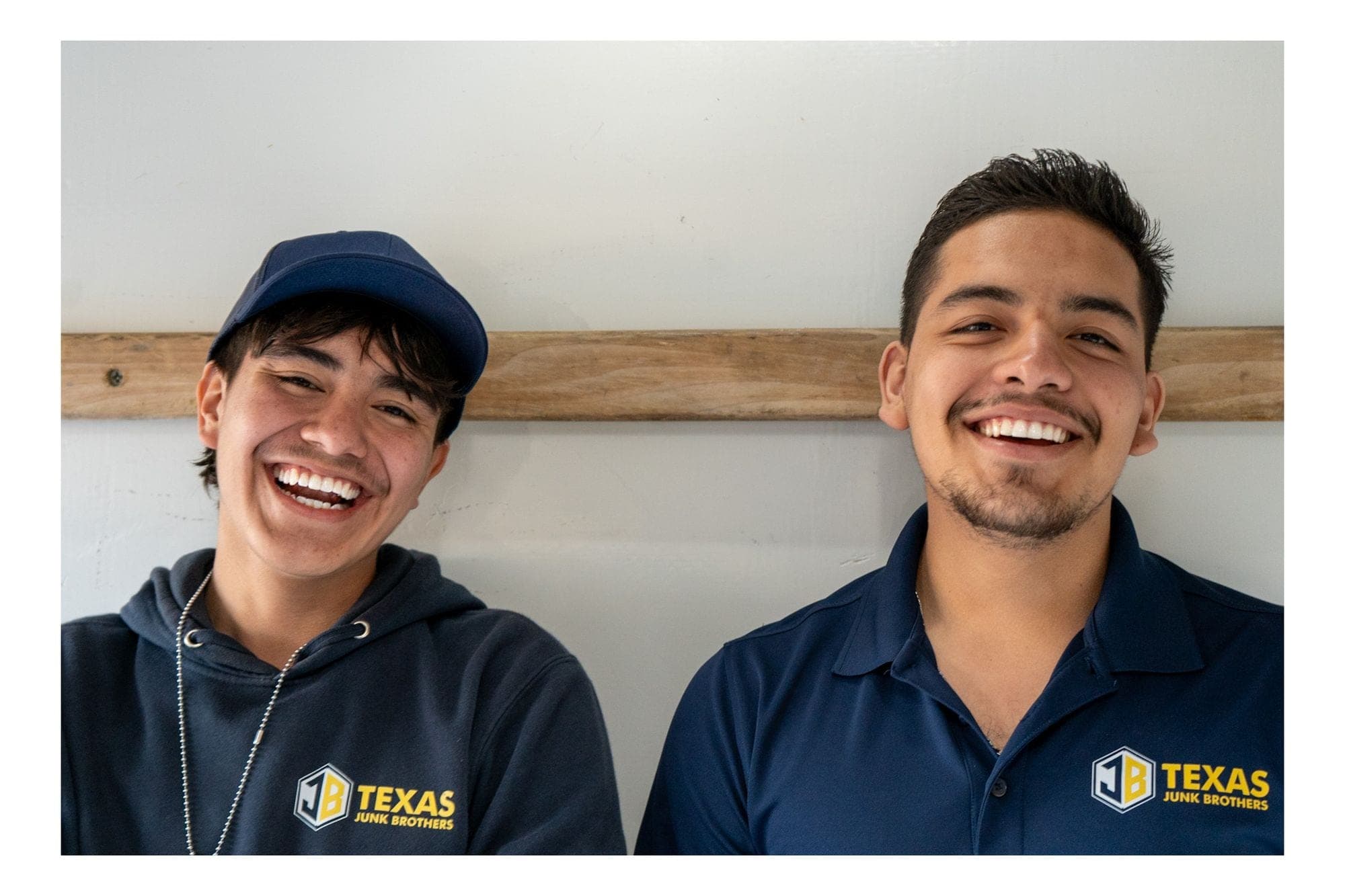 Erick and Jo from Texas Junk Brothers smiling, in branded polos